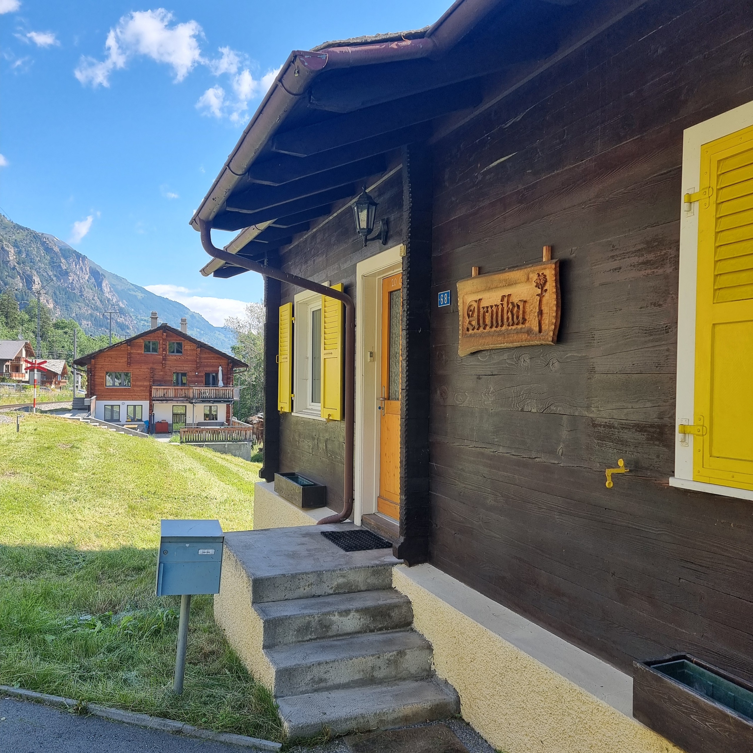 Alpines Holzhaus mit gelben Fensterläden