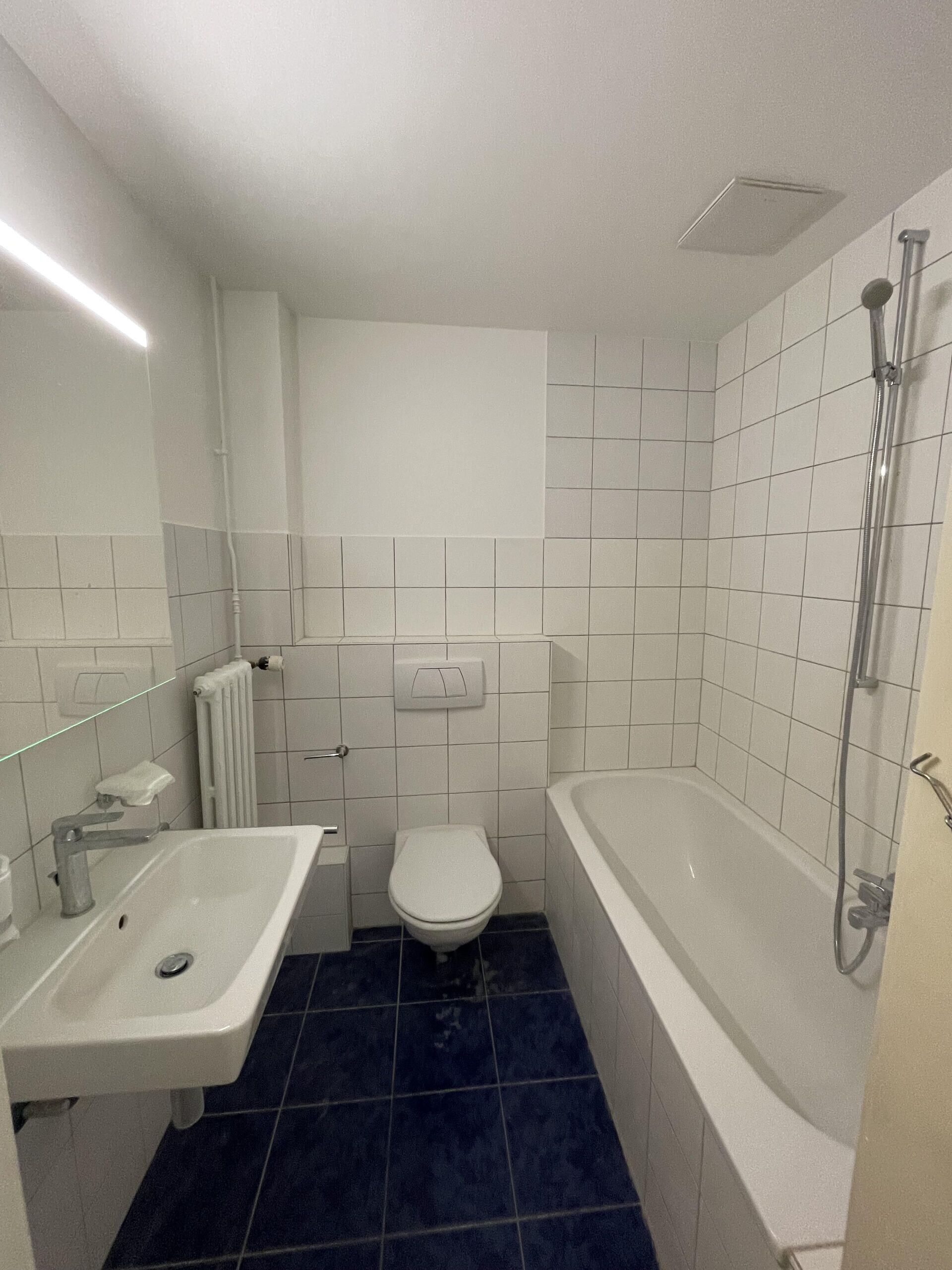 Kleines innenliegendes Badezimmer mit Badewanne, Waschbecken und WC