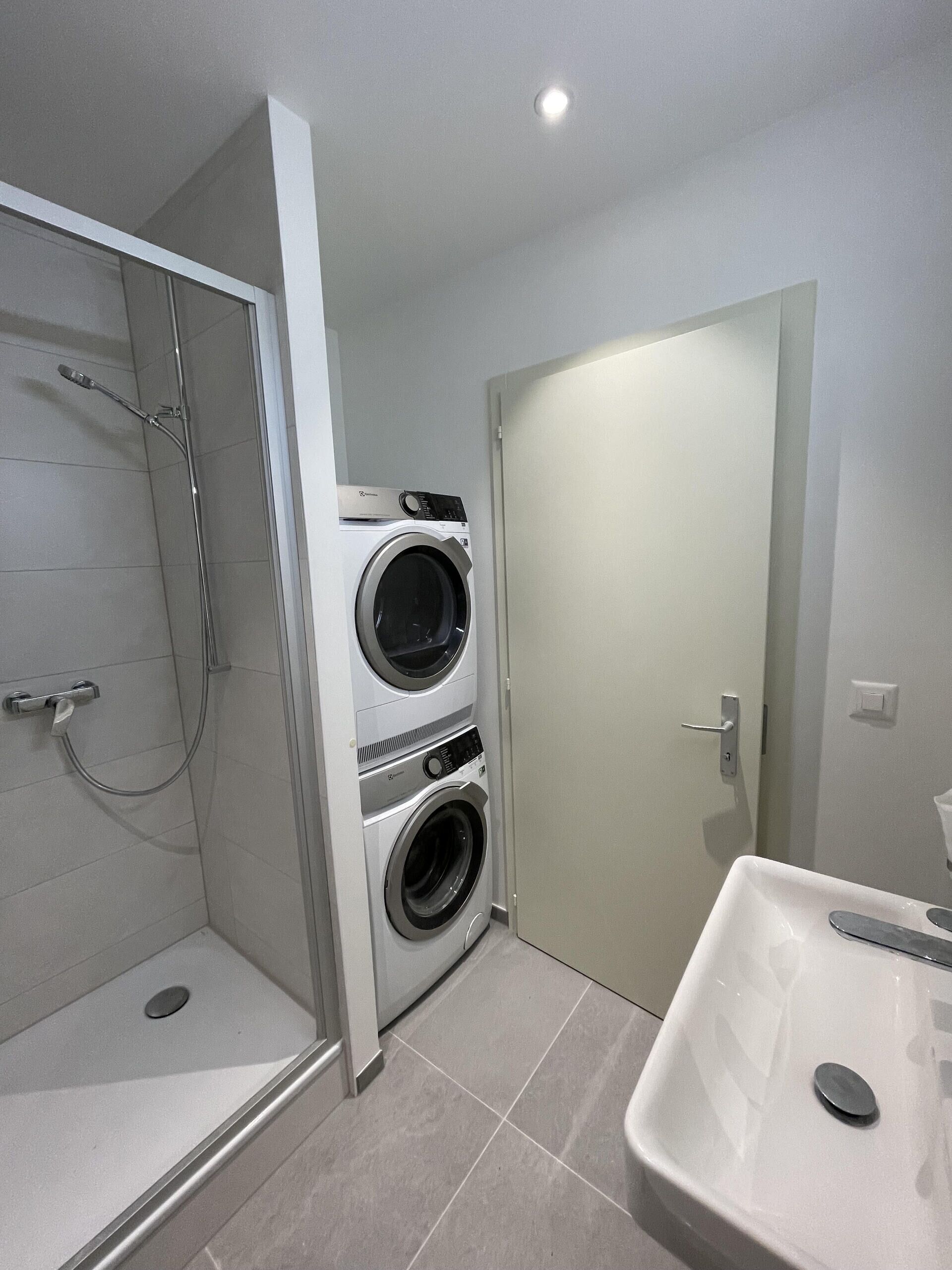 Modernes Bad mit Dusche und Waschmaschine