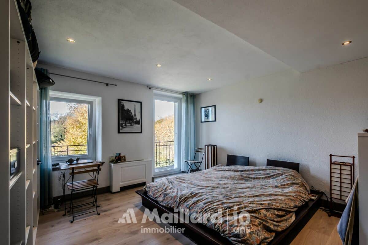 Schlafzimmer mit zwei Fenstern und Bett