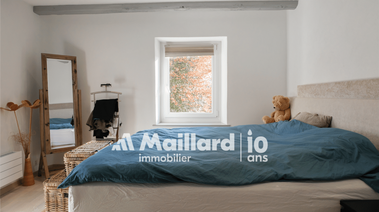 Helles Schlafzimmer mit rustikalem Spiegel und blauem Bett