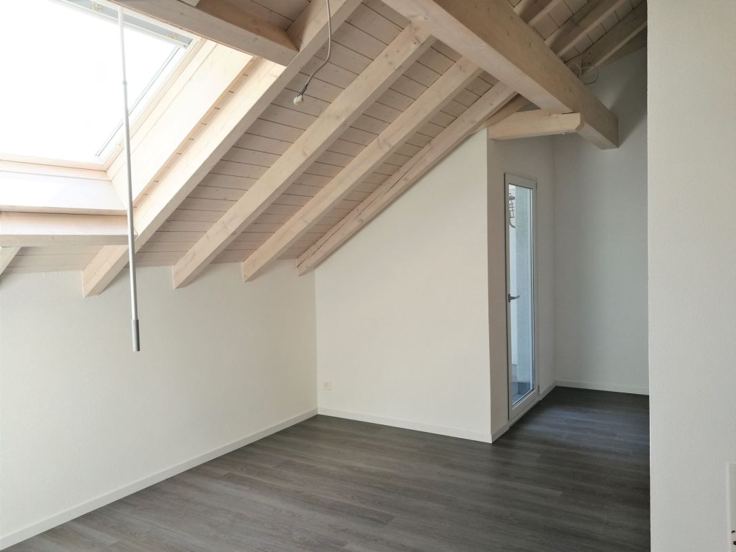 Dachgeschossraum mit sichtbaren Holzbalken