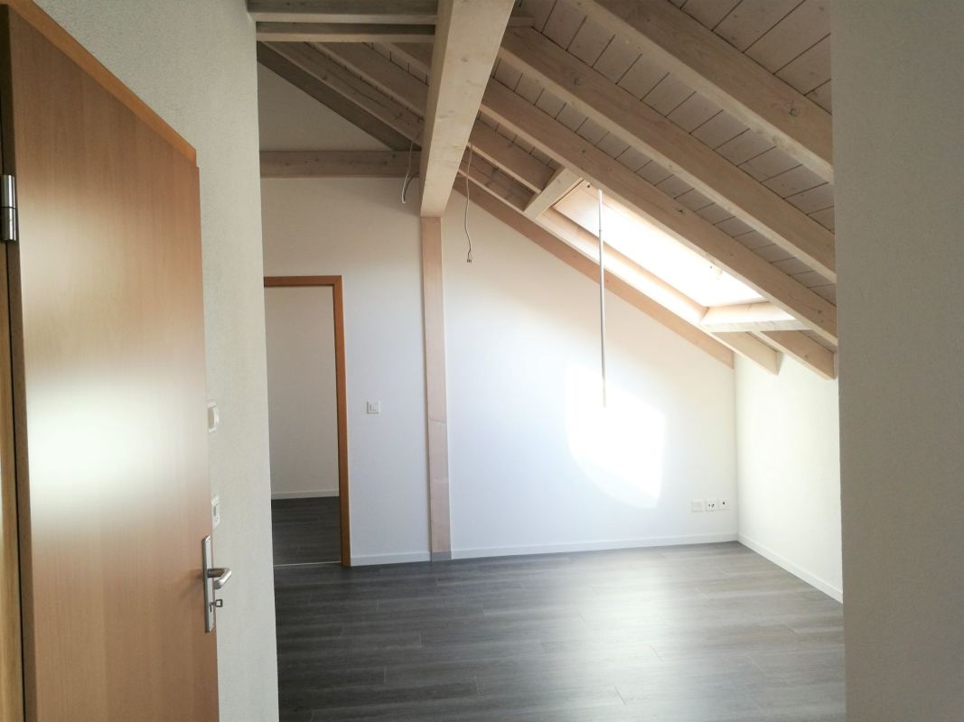 Dachgeschossraum mit sichtbaren Holzbalken