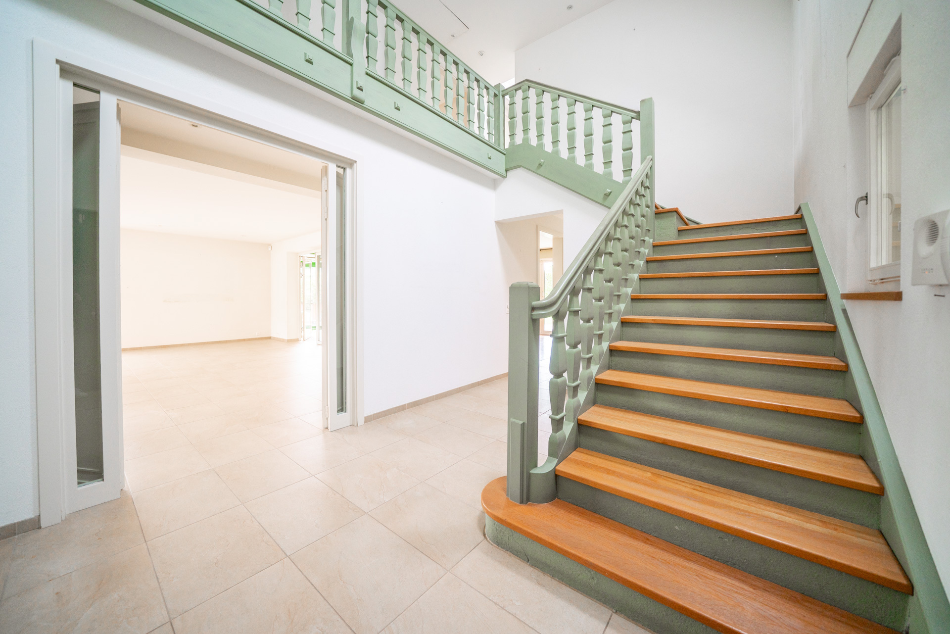 Heller Eingangsbereich mit Treppe und Galerie