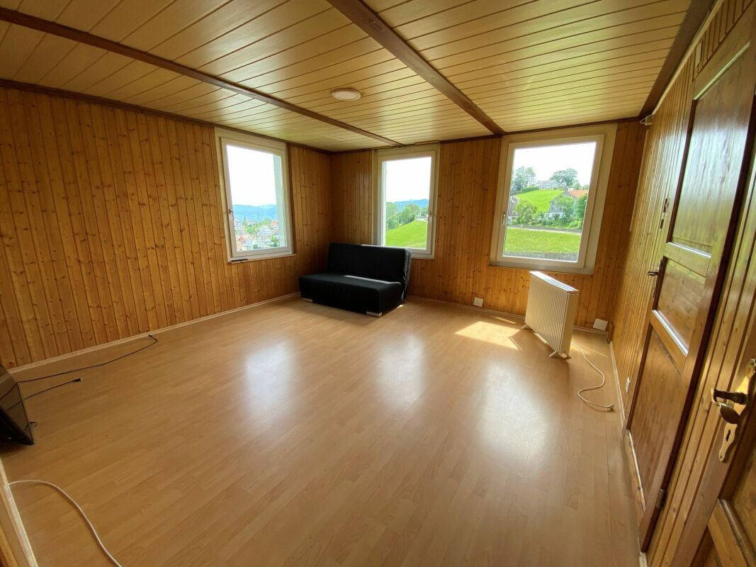 Holzvertäfelter Raum mit großen Fenstern