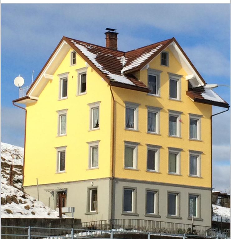 Gelbes Mehrfamilienhaus im Schnee