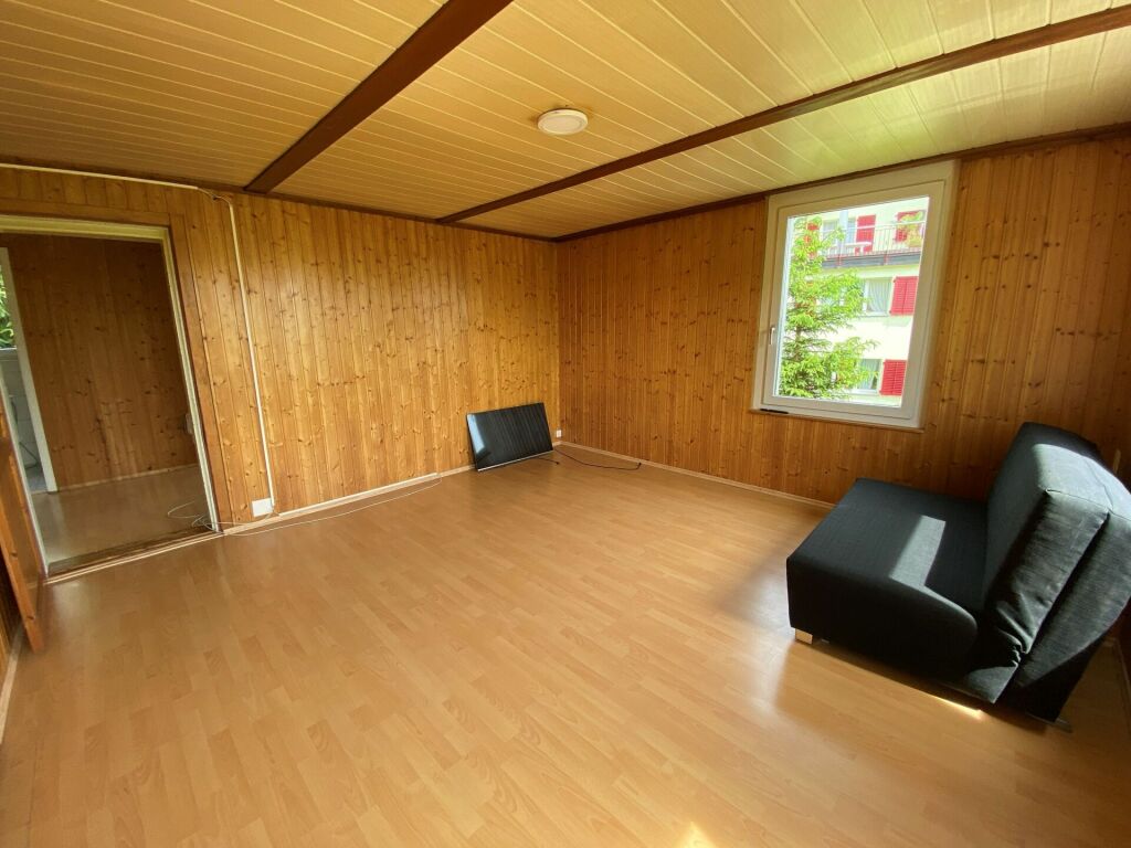 Holzvertäfelter Raum mit Fenster und Sofa
