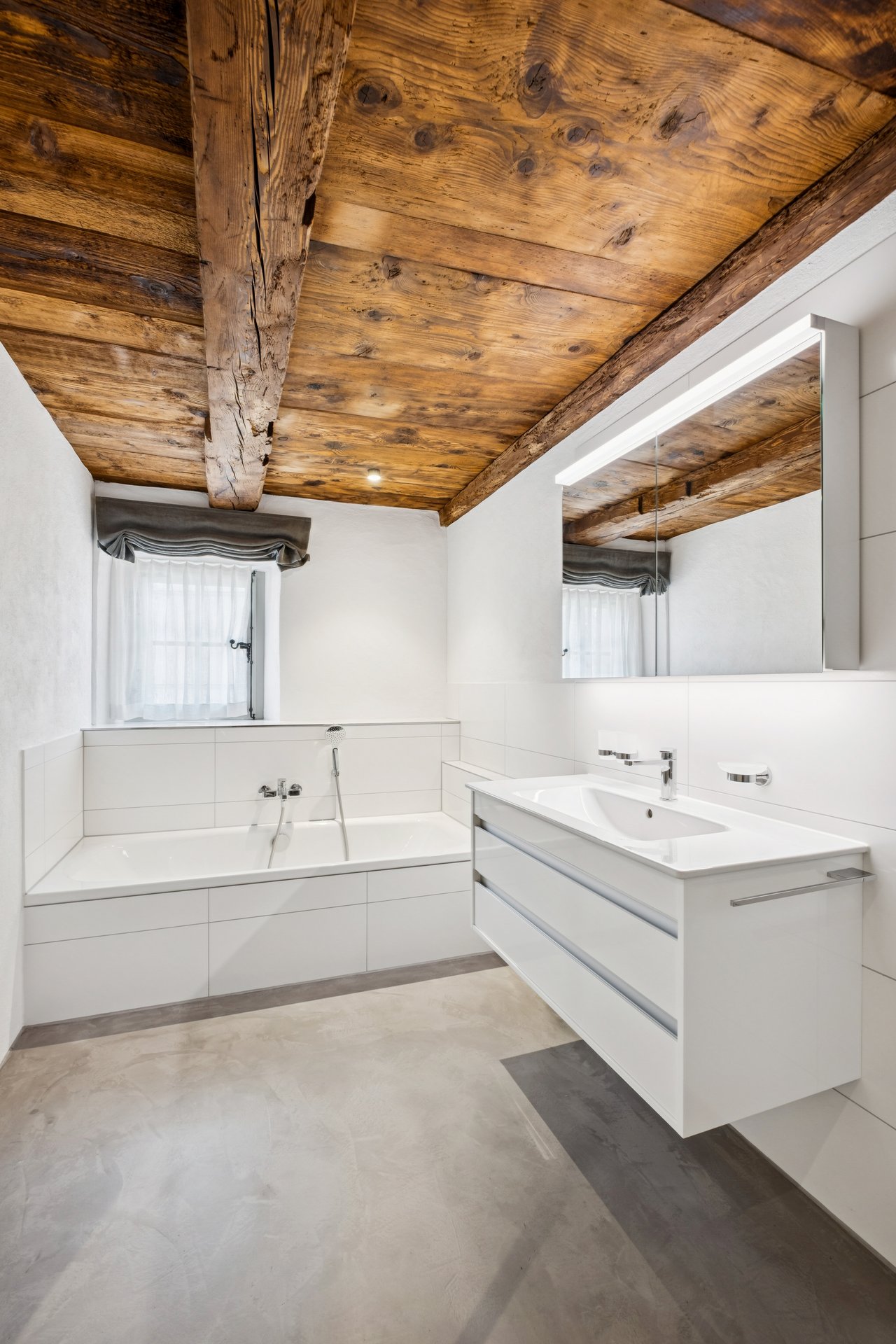 Modernes Badezimmer mit rustikaler Holzbalkendecke