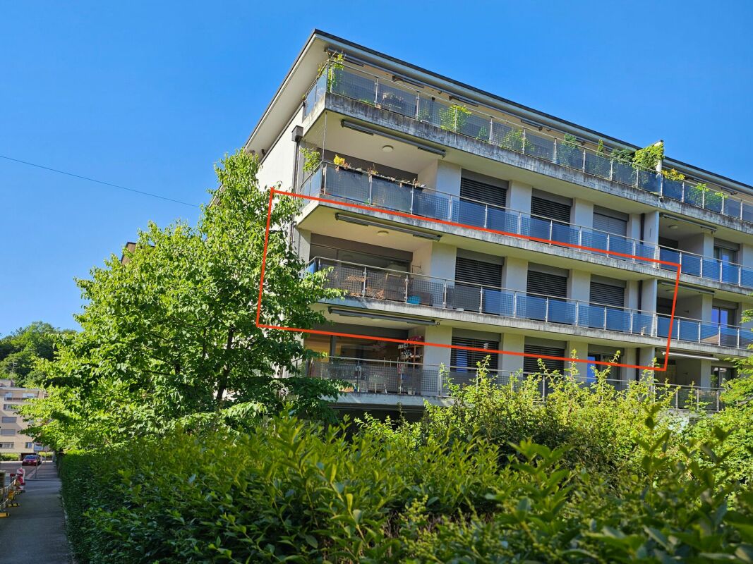 Mehrfamilienhaus mit Balkonen und Grünanlage