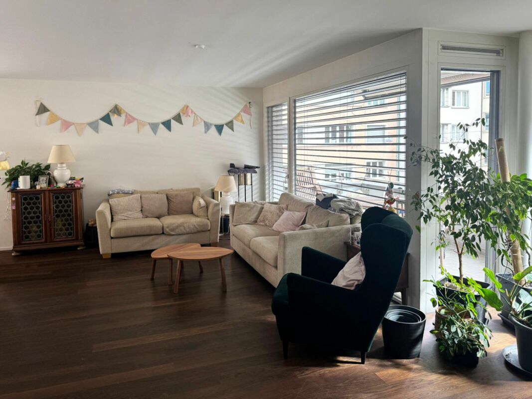 Helles Wohnzimmer mit Sitzgruppe und großem Fensterbereich