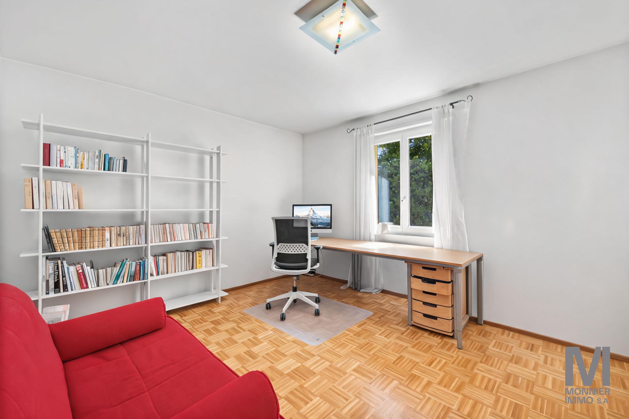 Helles Arbeitszimmer mit Schreibtisch und Bücherregal