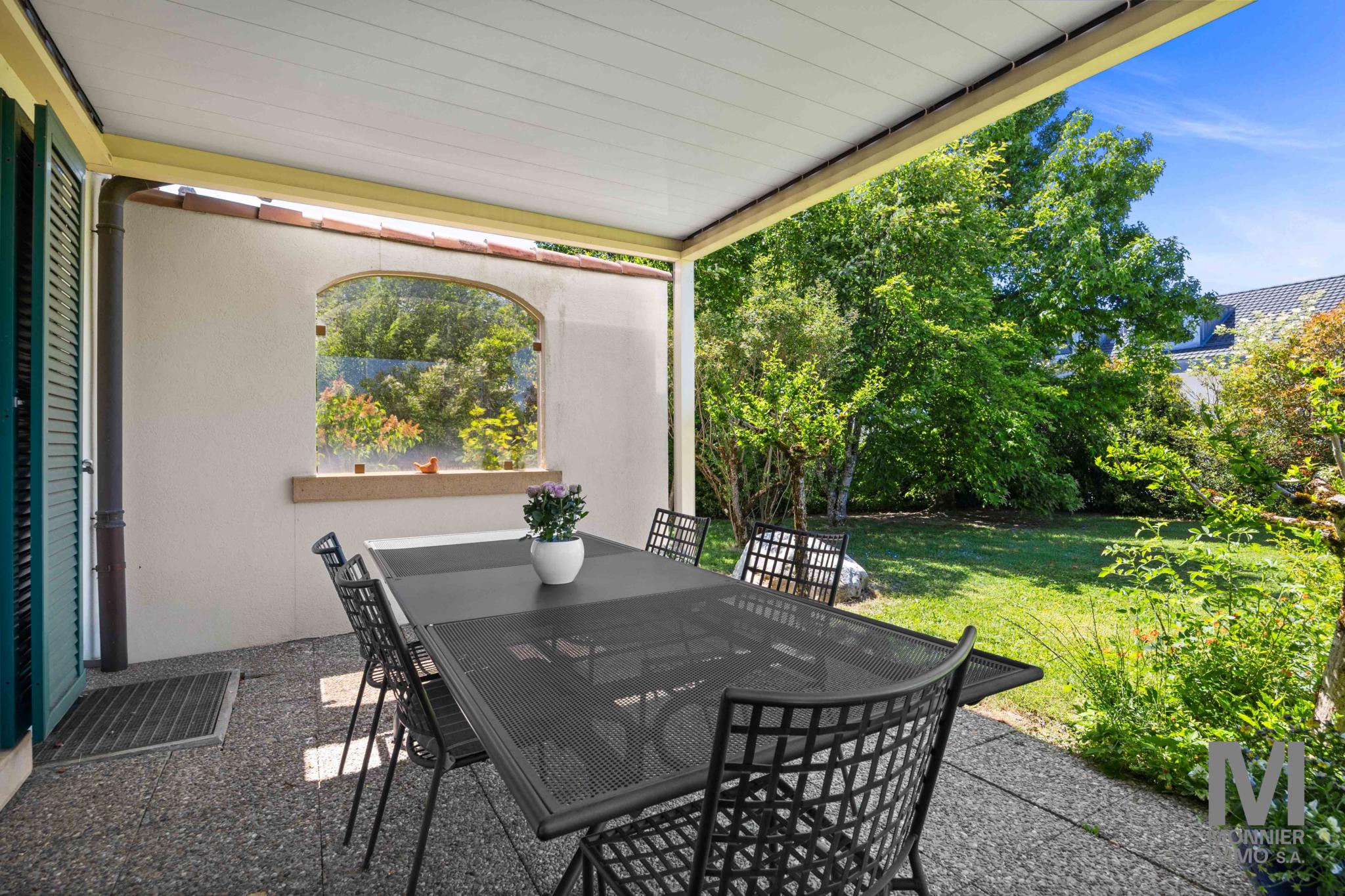Überdachte Terrasse mit Gartenblick