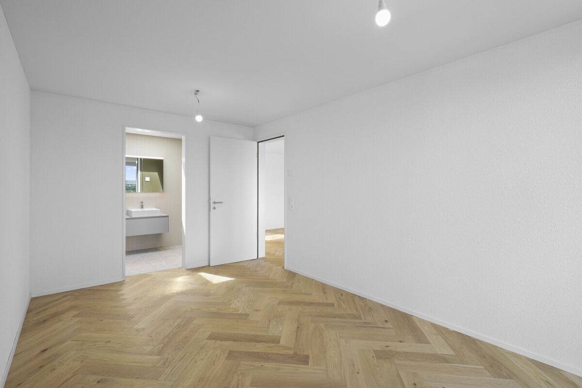 Helles, leeres Schlafzimmer mit offenem Badbereich