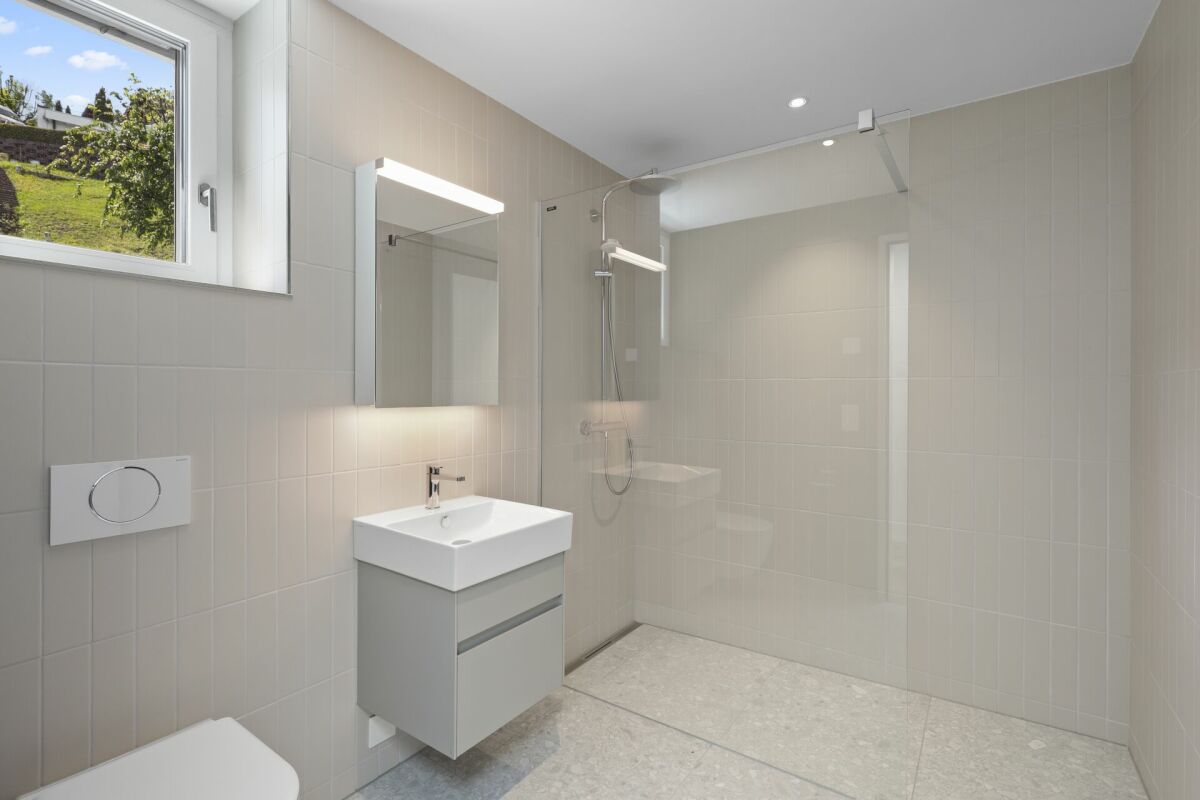 Helles, modernes Badezimmer mit Dusche und Waschbecken
