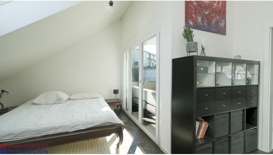 Schlafzimmer mit Dachschräge und Balkonzugang