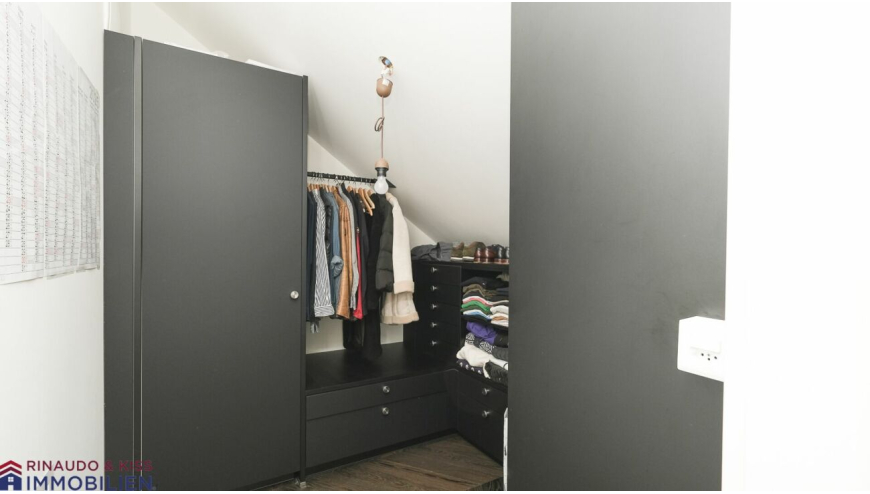 Begehbarer Kleiderschrank mit dunklen Einbauten