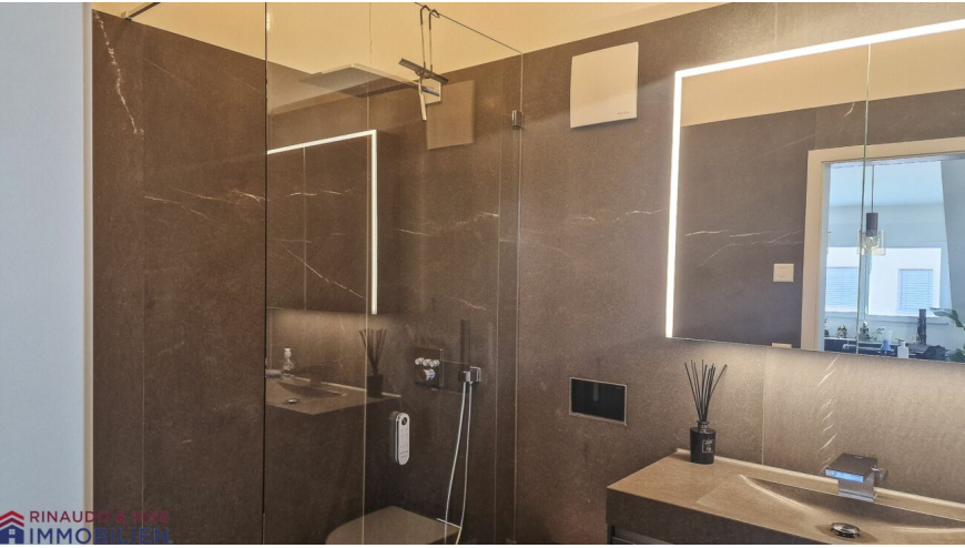 Modernes Badezimmer mit begehbarer Dusche und beleuchtetem Spiegel
