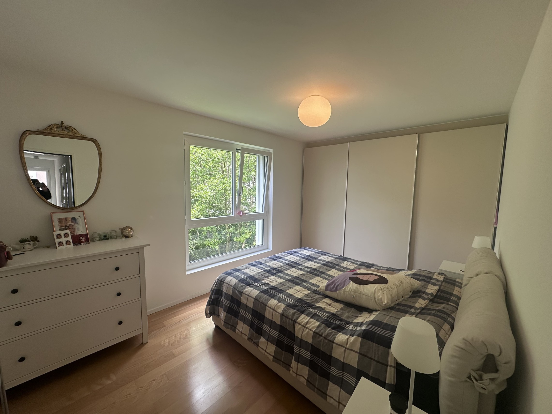Helles Schlafzimmer mit Fenster und Kleiderschrank