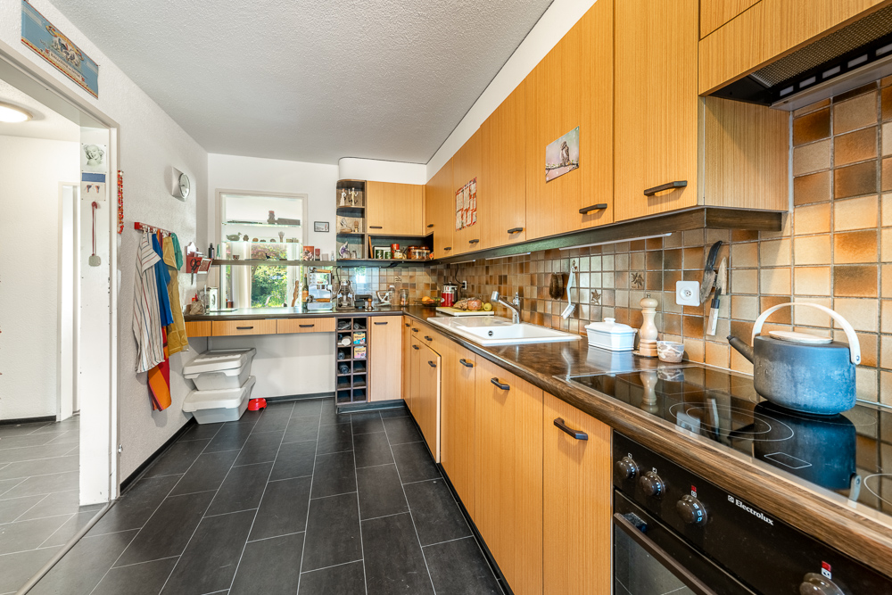 Küche mit warmen Holzfronten und dunklem Boden