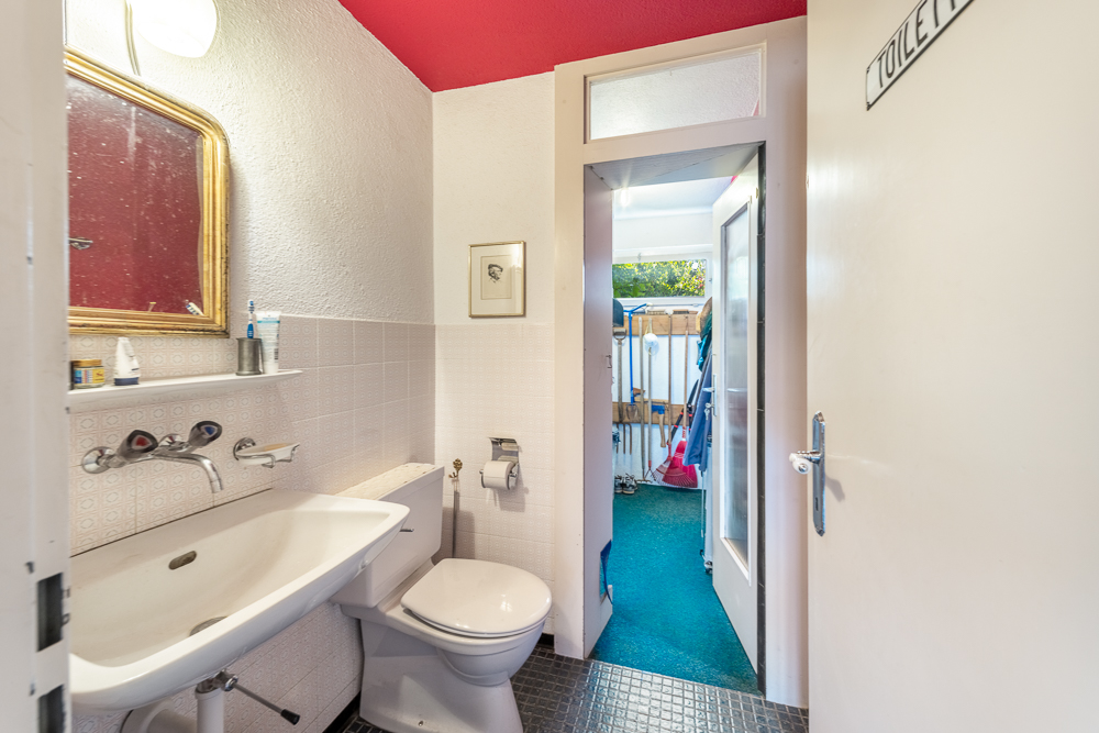 Kleines Gäste-WC mit Blick in einen Nebenraum