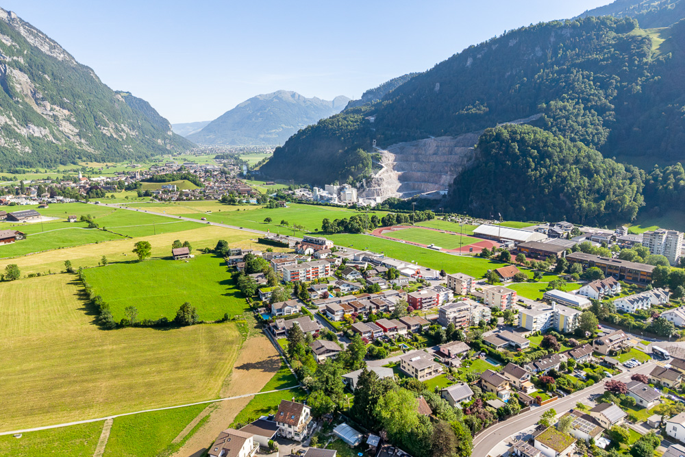 Luftaufnahme eines Tals mit Ortschaft und Bergen