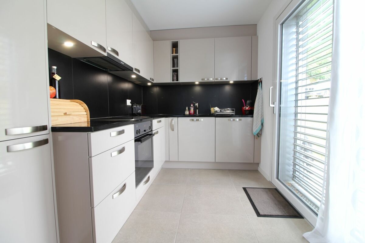 Moderne Einbauküche mit Fliesenboden