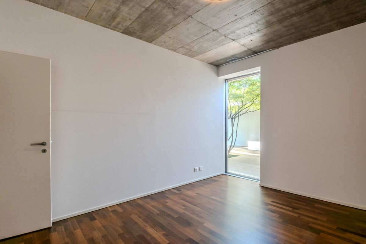 Leerer moderner Raum mit Tür und Gartenausblick