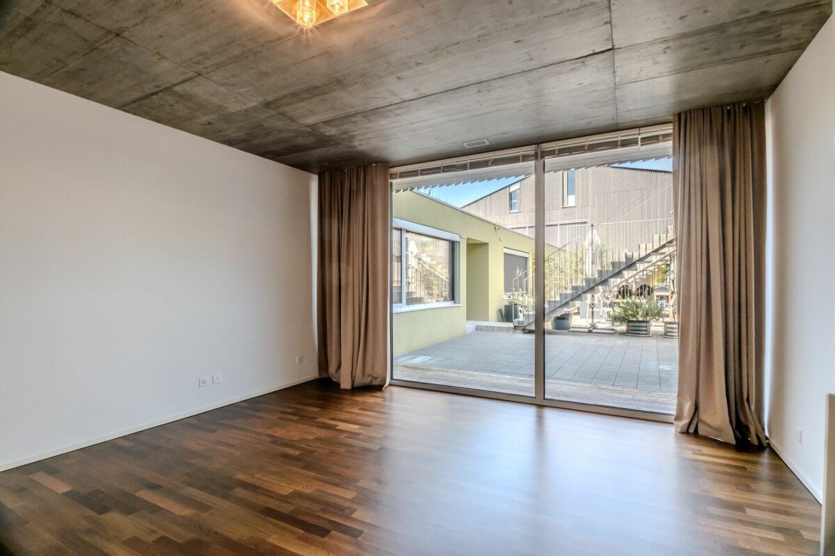Modernes Wohnzimmer mit großer Schiebetür zum Innenhof