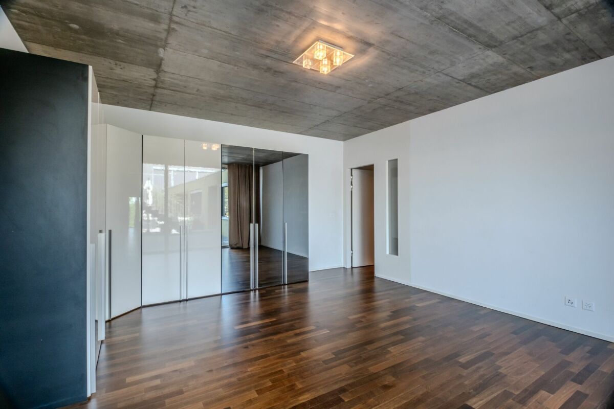 Modernes Schlafzimmer mit Beton-Decke und Holzfußboden