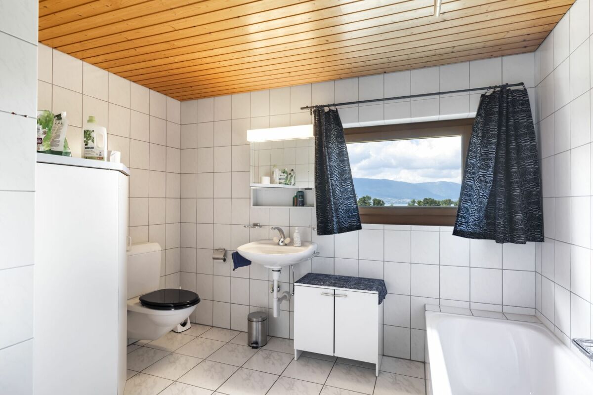 Badezimmer mit Holzdecke und Blick ins Freie