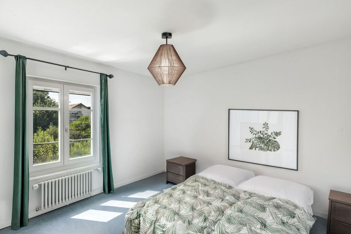 Helles Schlafzimmer mit grünem Akzent