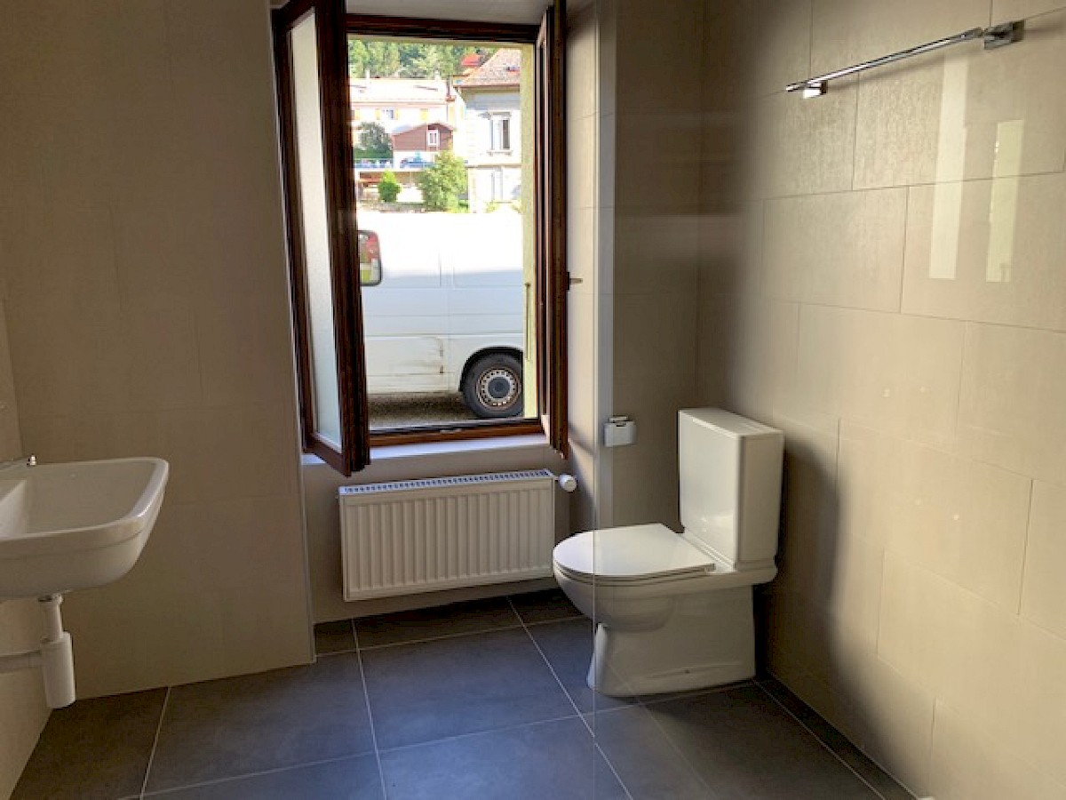 Modernes Badezimmer mit Fenster und WC