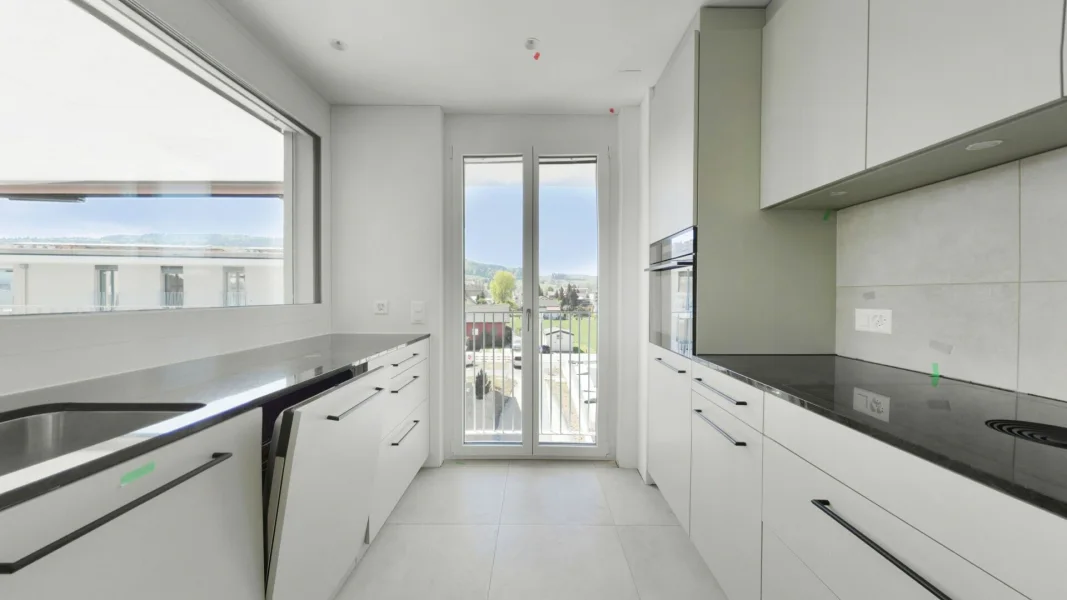 Moderne, helle Küche mit Balkonblick