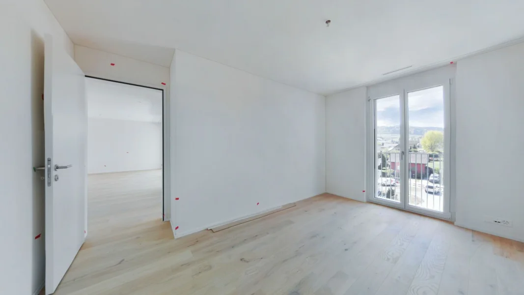 Helles, leeres Zimmer mit Balkonblick