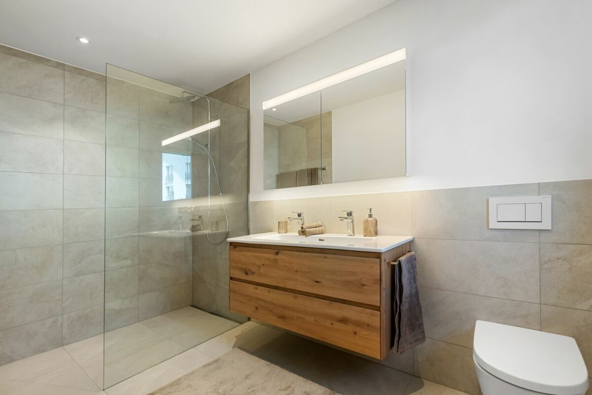 Modernes Badezimmer mit bodengleicher Dusche und Holzwaschtisch