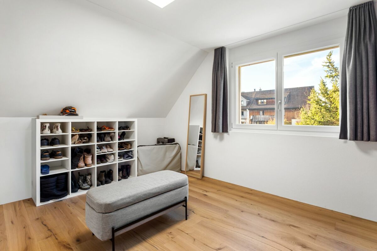 Helles Dachgeschosszimmer mit Fensterbank und Schuhregal