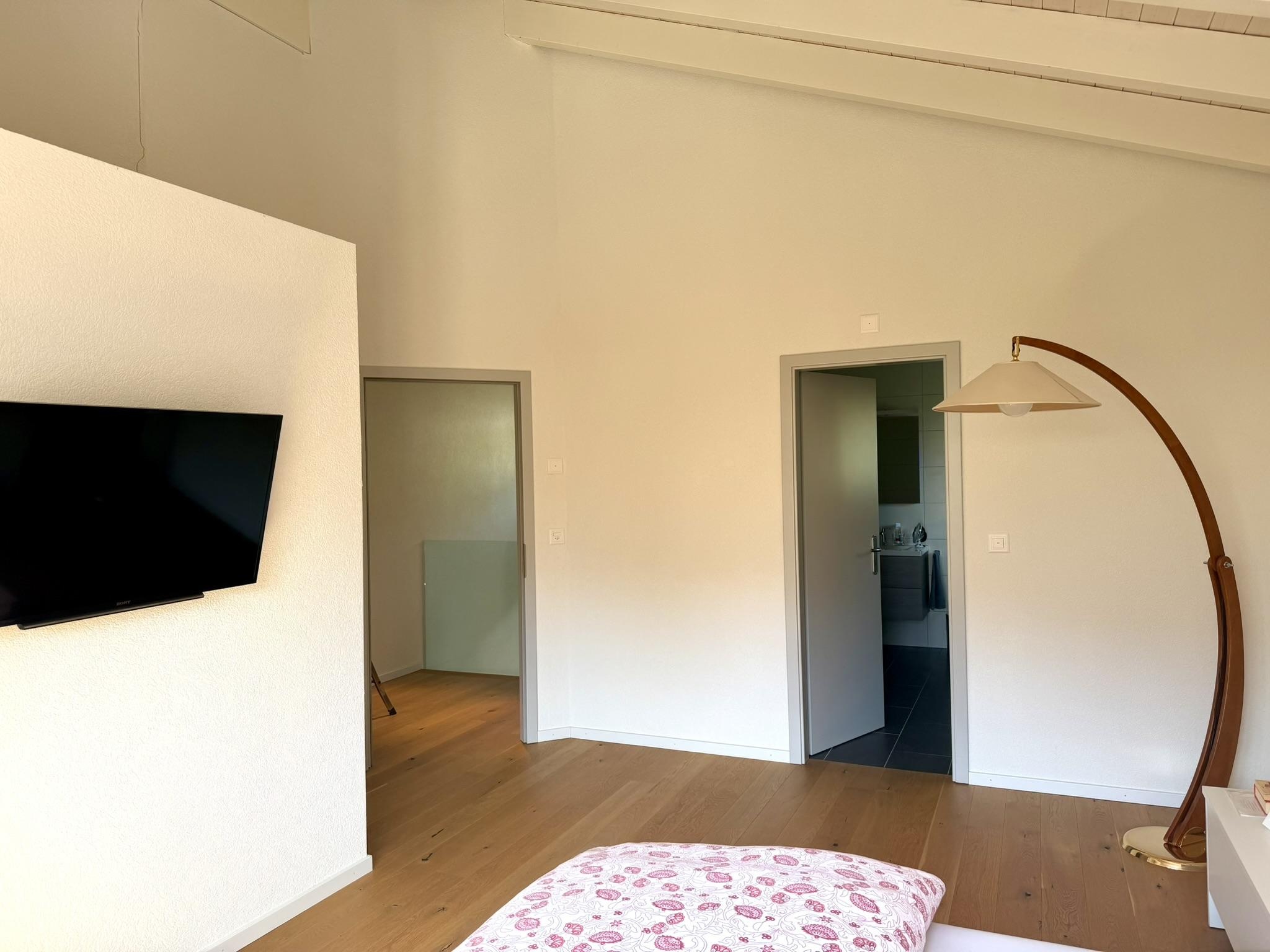 Helles Schlafzimmer mit offener Tür zum Bad