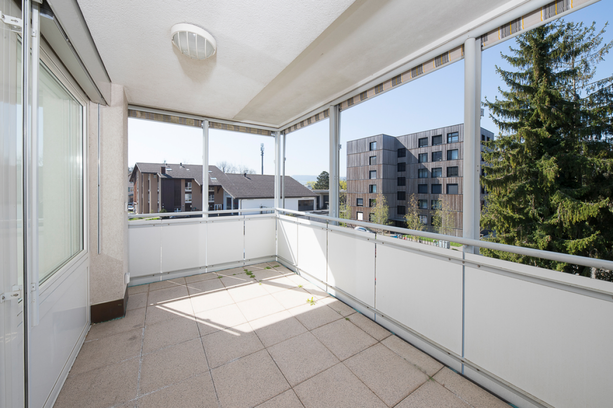 Überdachter Balkon mit Blick ins Wohnumfeld