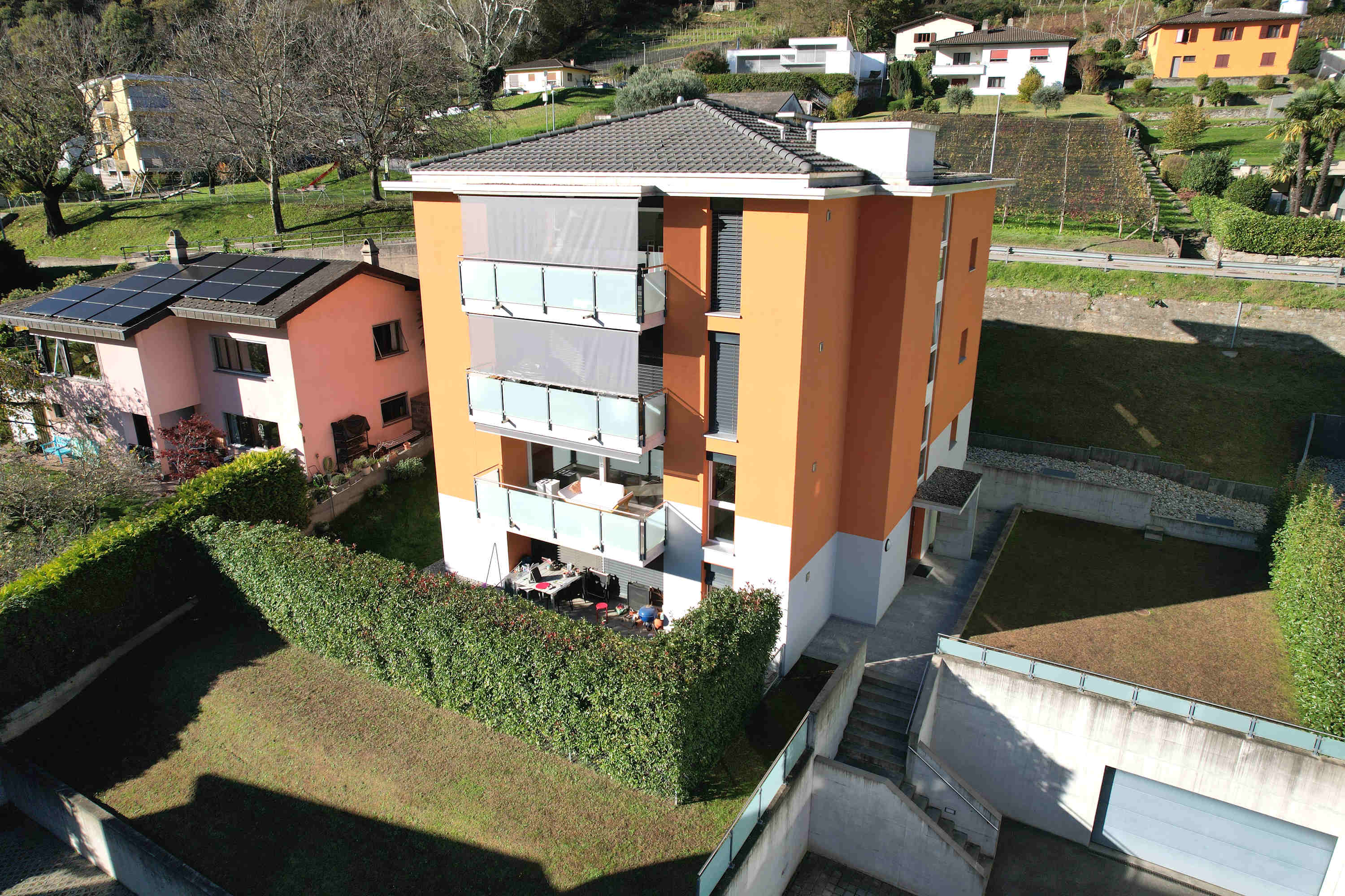 Luftaufnahme eines modernen Wohnhauses mit Terrassen und Solarmodulen