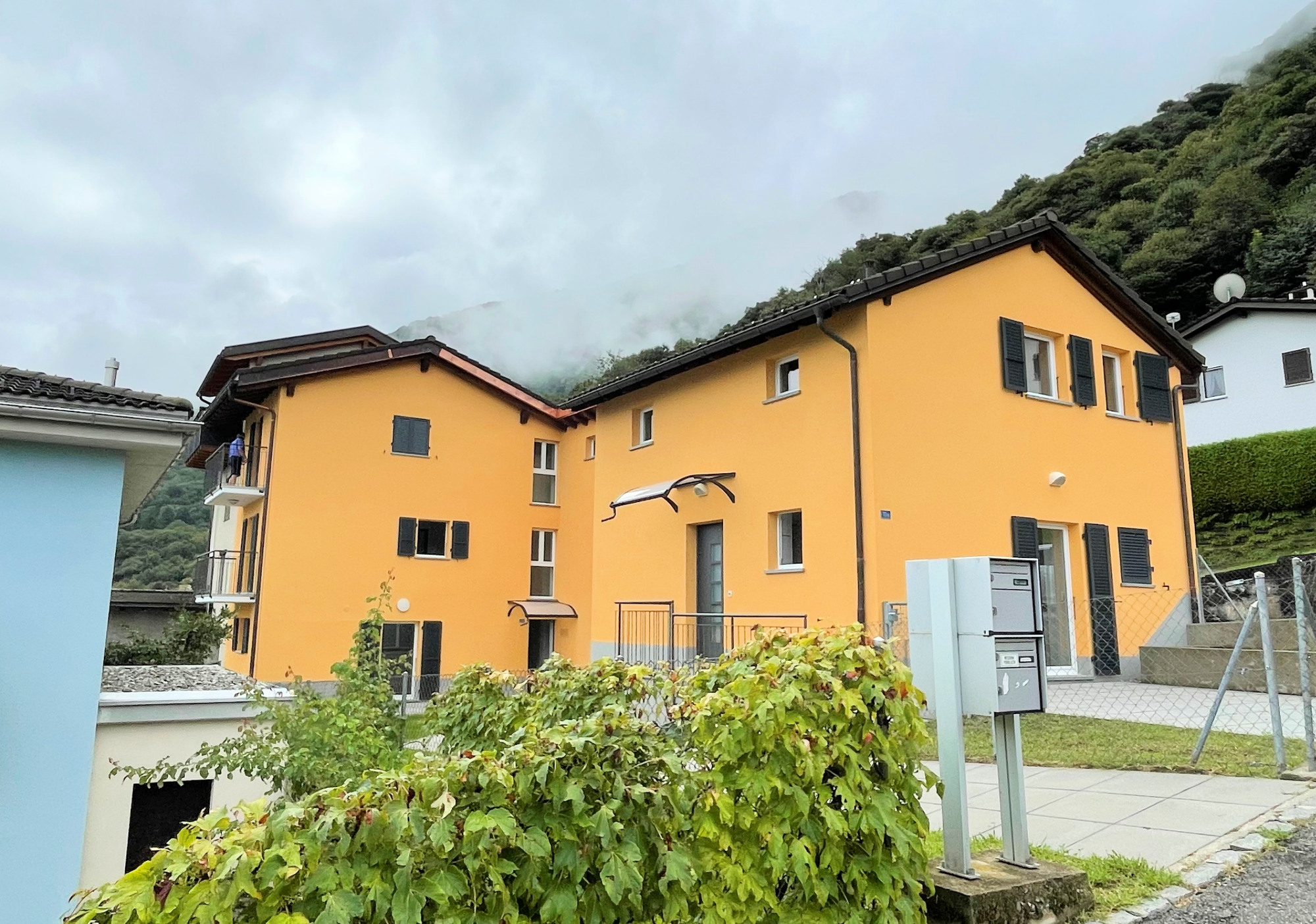 Außenansicht eines gelben Wohnhauses in Hanglage