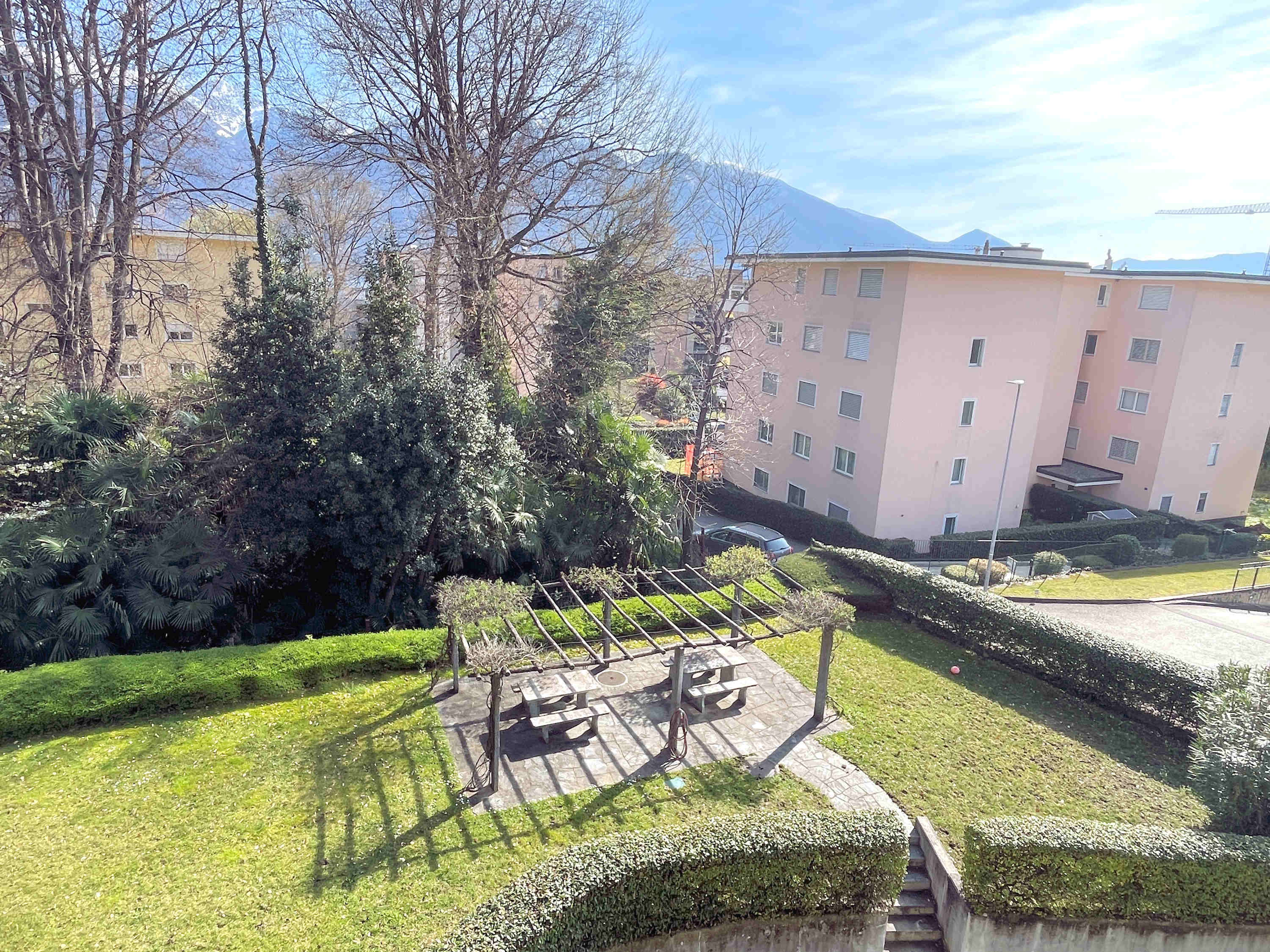 Blick auf Gartenanlage mit Pergola und Wohnhäusern