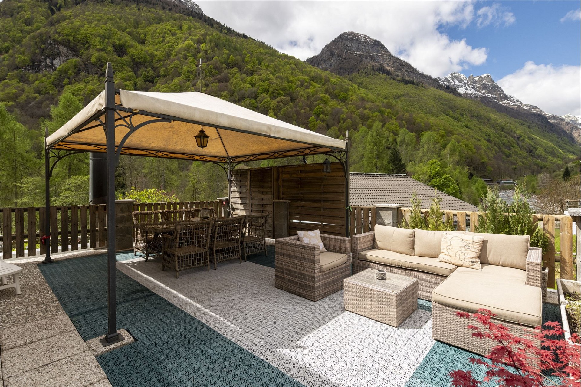 Überdachte Bergterrasse mit Lounge und Essbereich