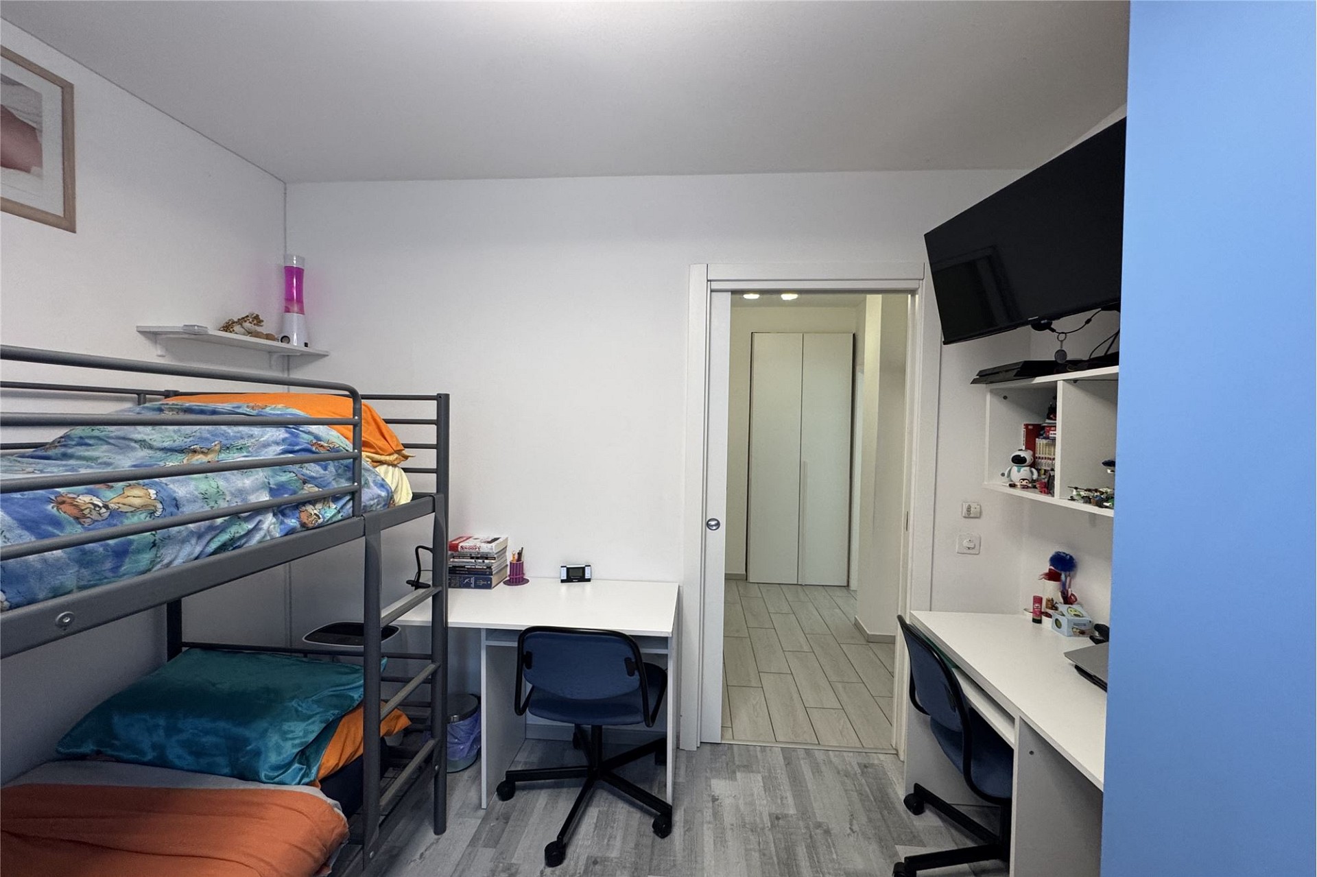 Kinderzimmer mit Etagenbett und zwei Schreibtischen