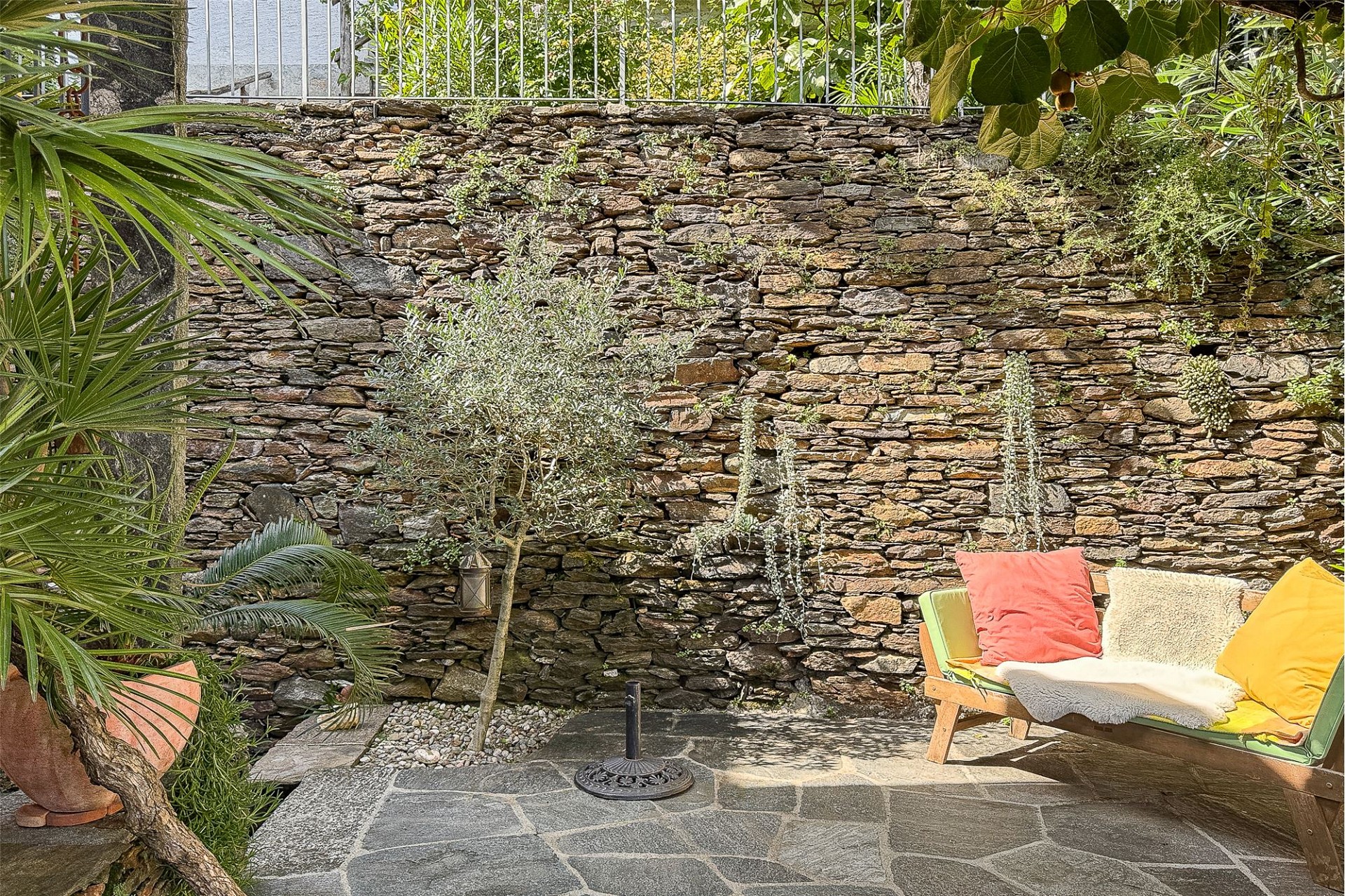 Mediterrane Gartenterrasse mit Natursteinmauer