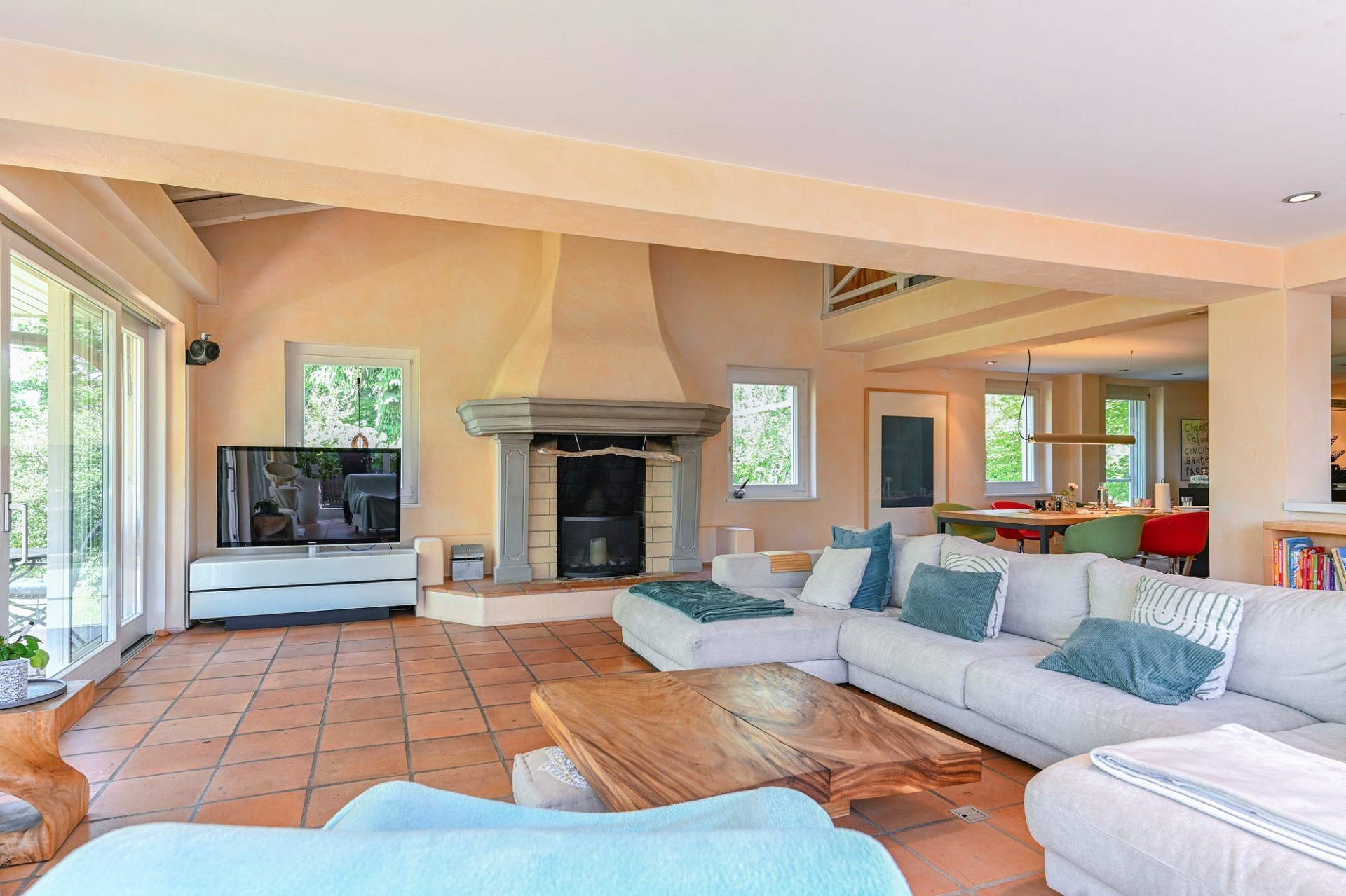 Offener Wohnbereich mit Kamin und Terrasse