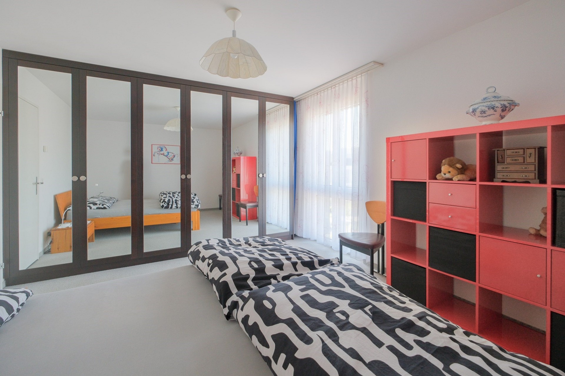 Helles Schlafzimmer mit Spiegelkleiderschrank und offenen Regalen
