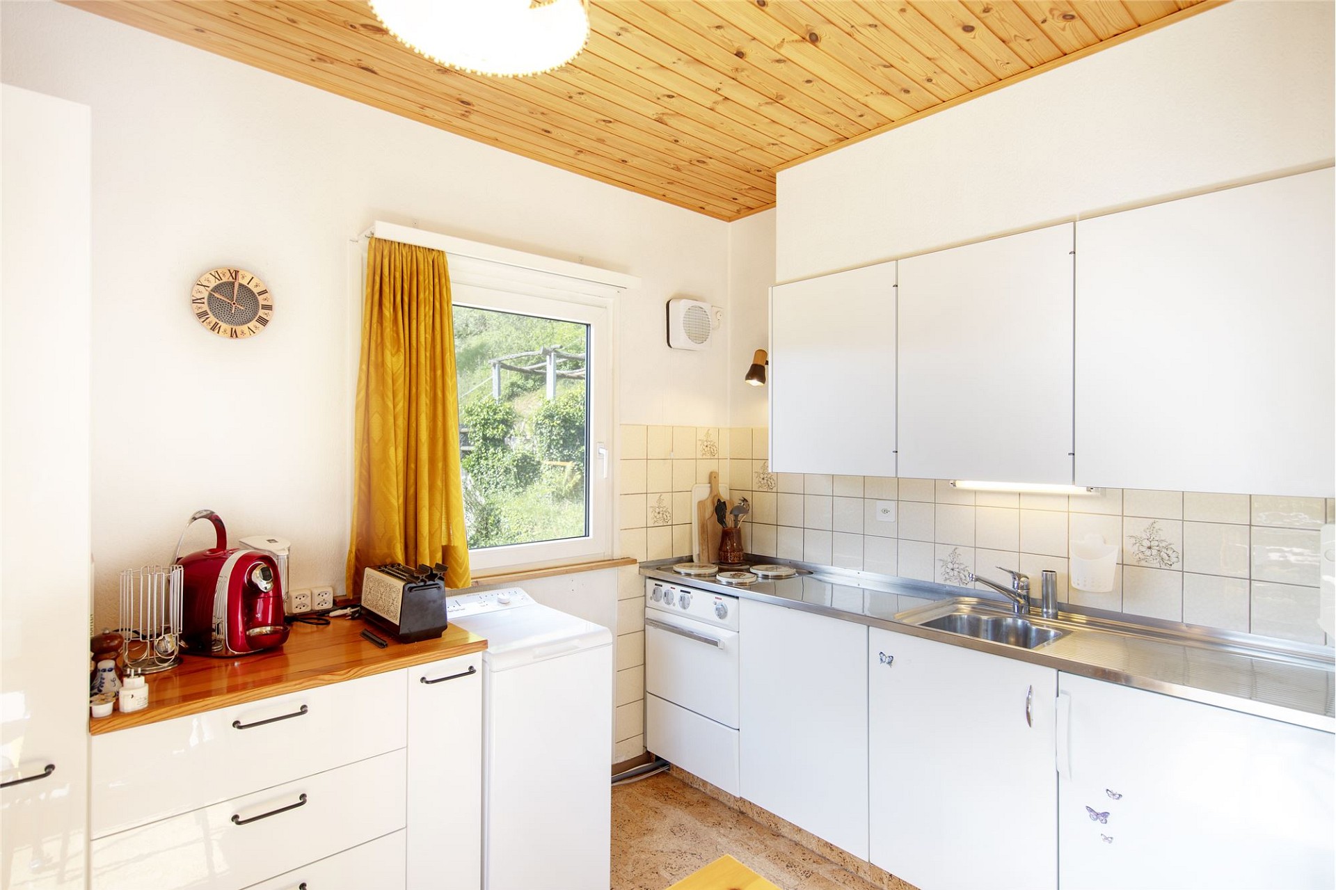 Helle Küche mit Holzdecke und weißen Fronten