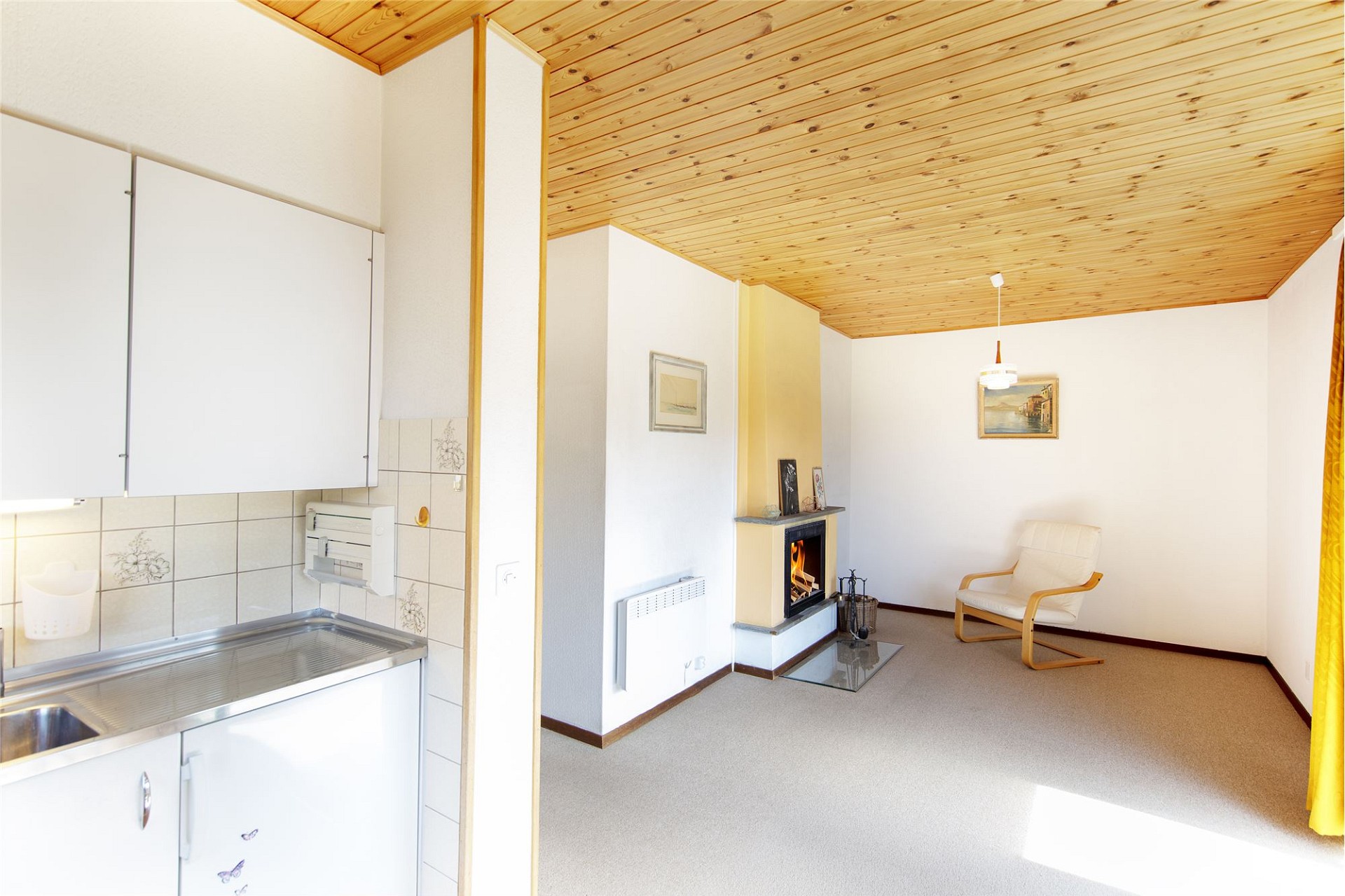 Wohnbereich mit Kamin und offener Küchenzeile