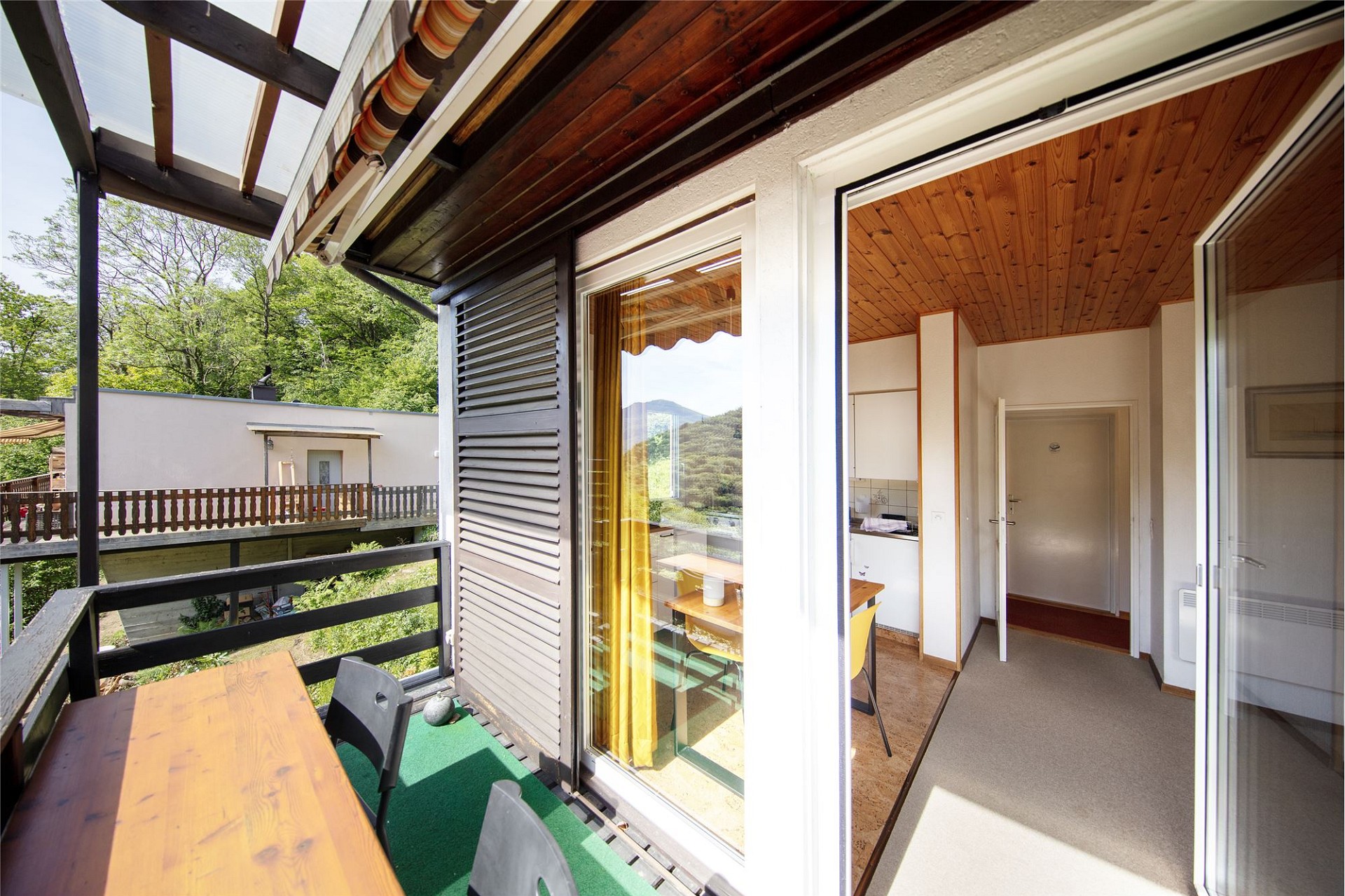 Balkon mit Blick ins Grüne und angrenzendem Innenbereich