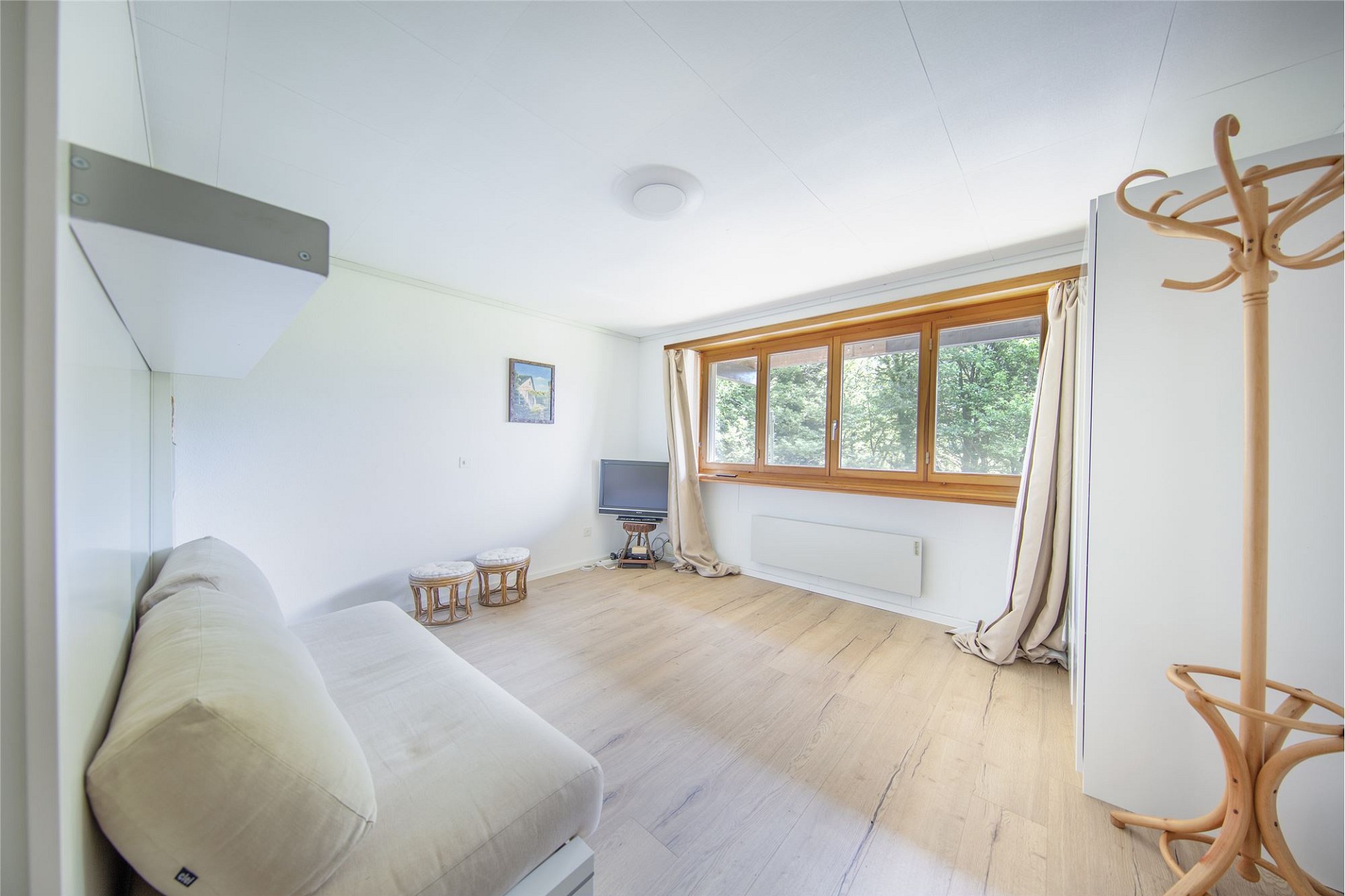 Helles Wohn-/Schlafzimmer mit Holzfenstern